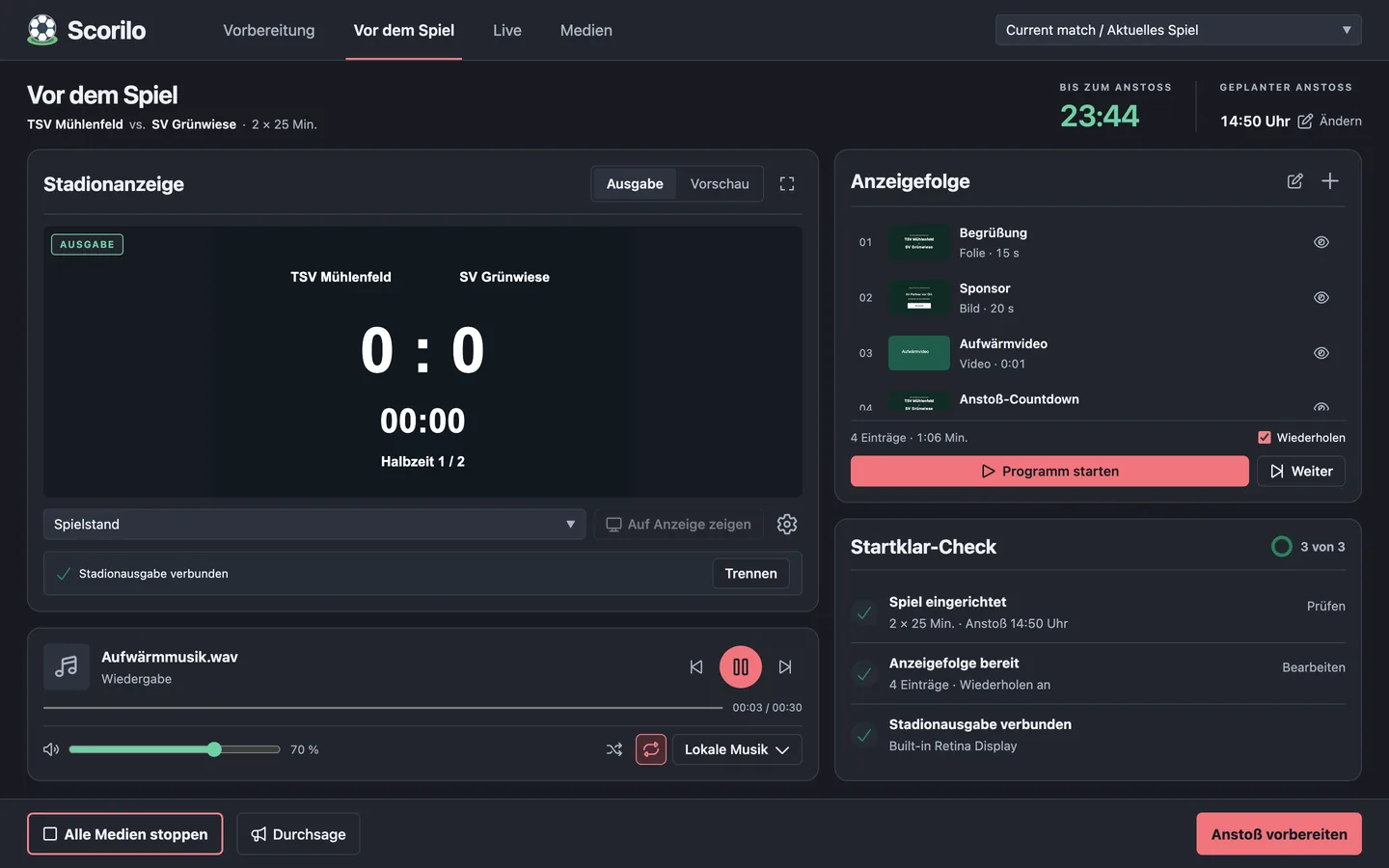 Die Ansicht „Vor dem Spiel“: Stadionanzeige mit Ausgabe und Vorschau, Anzeigefolge mit Begrüßung, Sponsor, Aufwärmvideo und Anstoß-Countdown, Musikplayer, Startklar-Check mit drei erfüllten Punkten und der Countdown bis zum Anstoß.